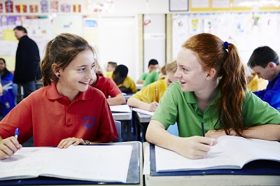 Two female students chatting at their desk