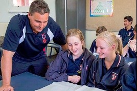 Teacher helping students at their desk