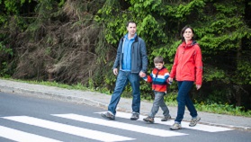 Parents walking son across road