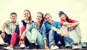 Group of teenagers sitting and smiling at camera